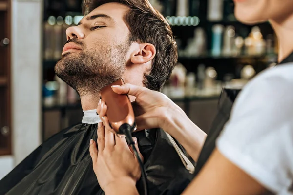 Обрізаний знімок перукарської обрізки бороди до красивого клієнта в салоні краси — стокове фото