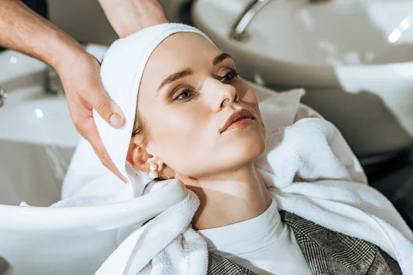 Schnappschuss von Friseur, der junge Frau in Schönheitssalon die Haare wäscht — Stockfoto
