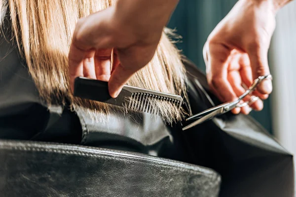 Gros plan vue partielle de coiffeur couper les cheveux à belle jeune femme dans le salon de beauté — Photo de stock
