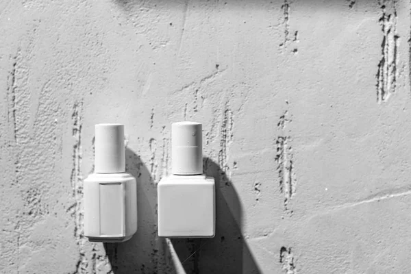 Vista de cerca de esmaltes de uñas decorativos blancos en la pared en el salón de belleza - foto de stock