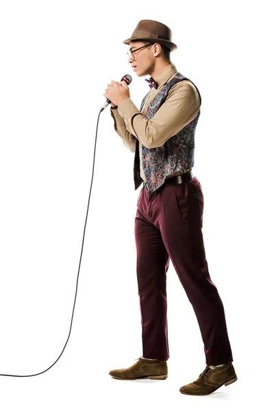Jeune métis masculin musicien en chapeau chantant au microphone isolé sur blanc — Photo de stock