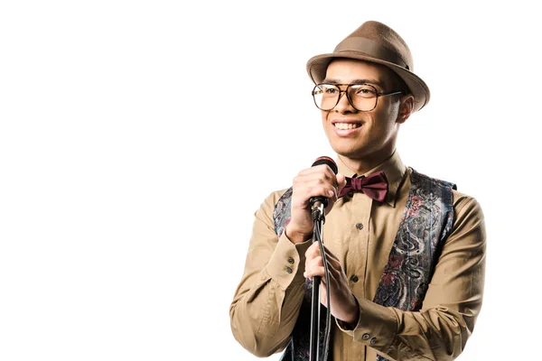 Mixed race man in stylish hat and eyeglasses singing in microphone isolated on white — Stock Photo