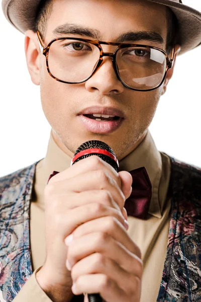 Портрет молодого музыканта смешанной расы, поющего в микрофоне, изолированном на белом — стоковое фото