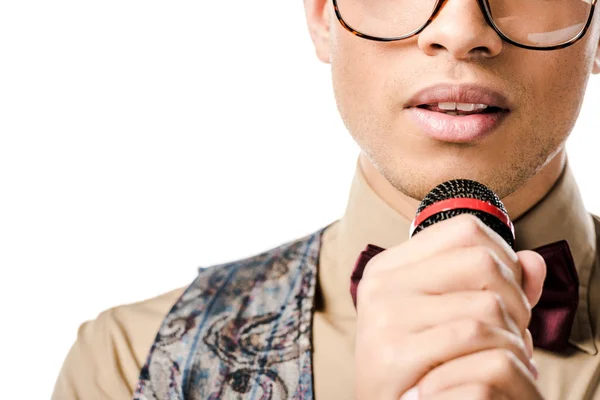 Vista parcial del joven músico mestizo en gafas cantando en micrófono aislado en blanco - foto de stock