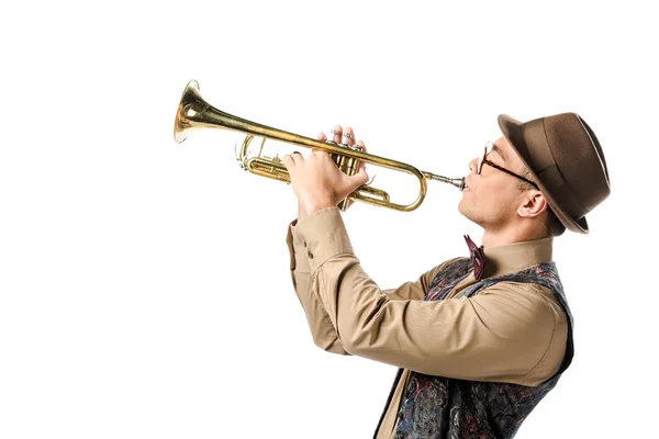 Vue latérale du musicien mixte masculin en chapeau élégant et lunettes de vue jouant sur trompette isolée sur blanc — Photo de stock