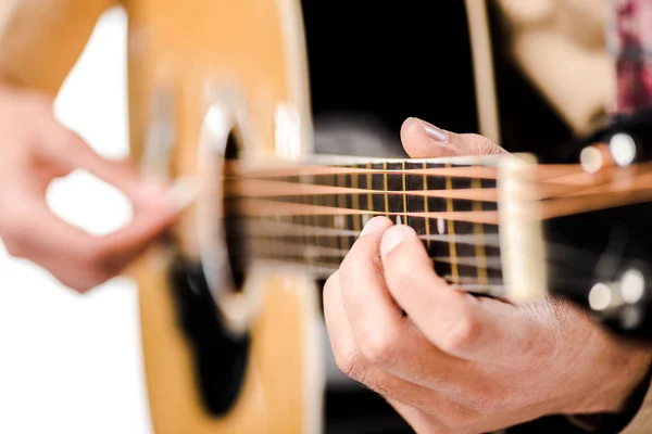 Enfoque selectivo del músico masculino tocando la guitarra acústica aislado en blanco - foto de stock