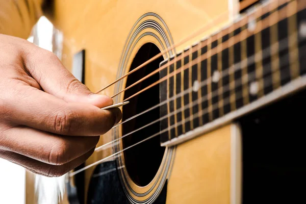 Частичный взгляд мужчины-музыканта, играющего на акустической гитаре, изолированной на белом — стоковое фото