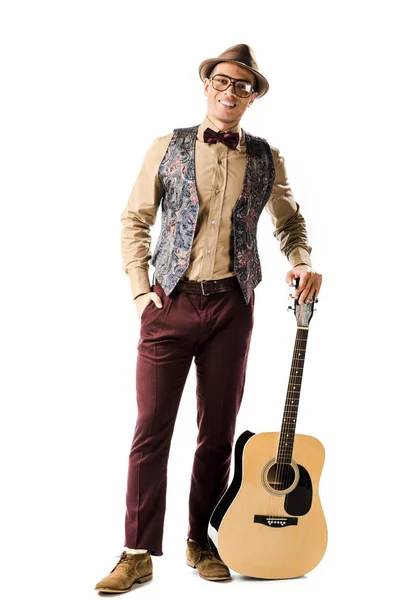 Happy male musician in hat and eyeglasses posing with acoustic guitar isolated on white — Stock Photo