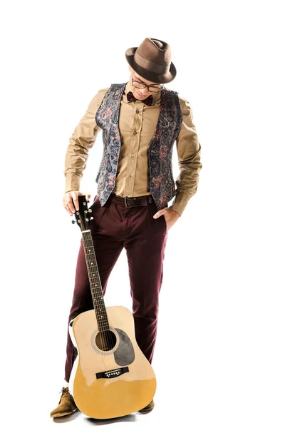 Мужчина-музыкант в шляпе и очках позирует с акустической гитарой, изолированной на белом — стоковое фото