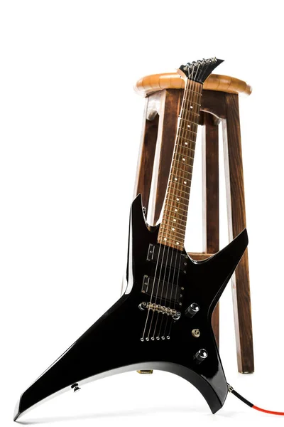 Black electric guitar near wooden chair isolated on white — Stock Photo