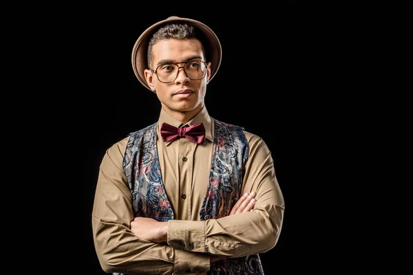 Confident young male model in vest and bow tie posing isolated on black — Stock Photo