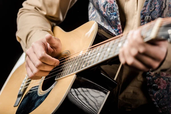 Imagem recortada de músico masculino tocando na guitarra acústica isolada no preto — Fotografia de Stock