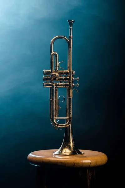 Studio shot of trumpet on chair with dramatic lighting background — Stock Photo