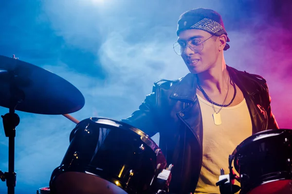 Mixed race male musician playing drums during rock concert on stage — Stock Photo