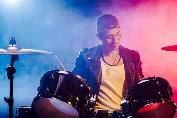 Молодой музыкант смешанной расы, играющий на барабанах во время рок-концерта на сцене — стоковое фото