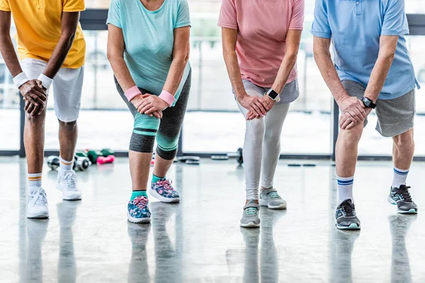 Immagine ritagliata di sportivi anziani esercizio sincrono presso palazzetto dello sport — Foto stock