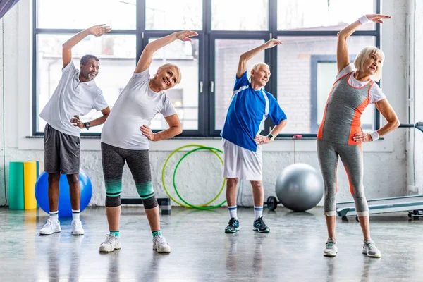 Щасливі багатоетнічні спортсмени синхронні вправи в спортивному залі — стокове фото