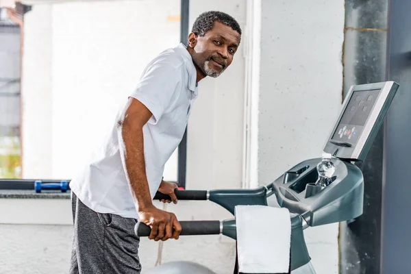 Afrikanisch-amerikanischer Mann mittleren Alters auf Laufband im Fitnessstudio — Stockfoto