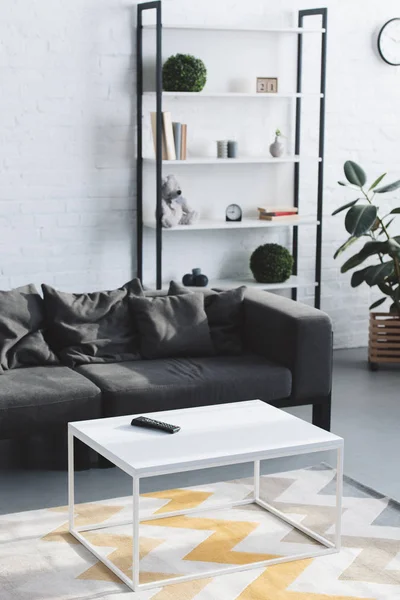 Moderno soggiorno interno con accogliente divano, tavolo e librerie — Foto stock