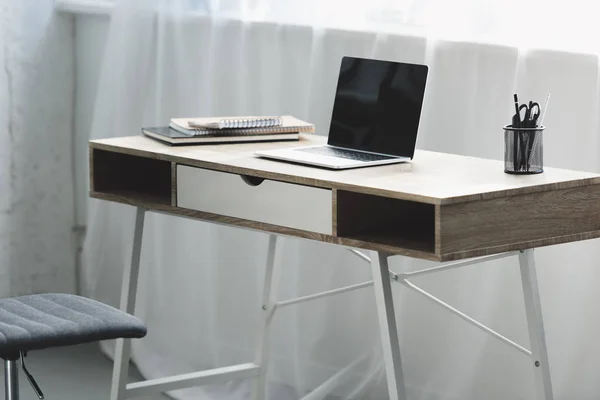 Portátil con pantalla en blanco en escritorio de madera en el lugar de trabajo - foto de stock