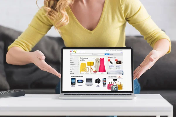 Cropped shot of woman showing laptop with ebay website on screen — Stock Photo