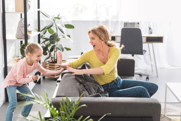 Mãe feliz e filha se divertindo e brincando juntos em casa — Fotografia de Stock