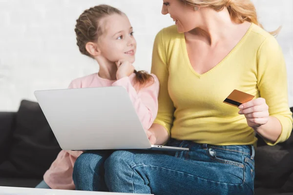 Cropped shot of mother and daughter smiling each other while shopping online at home — Stock Photo
