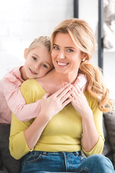 Belle mère heureuse et fille étreignant et souriant à la caméra — Photo de stock