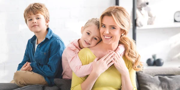 Happy mother and cute little kids spending time together and smiling at camera — Stock Photo