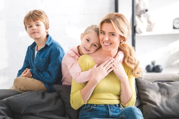 Happy mother and cute little children spending time together and smiling at camera — Stock Photo