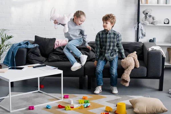 Fröhliches Geschwisterpaar spielt zu Hause mit Spielzeug — Stockfoto