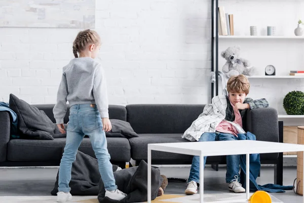 Niños traviesos jugando con ropa en casa - foto de stock