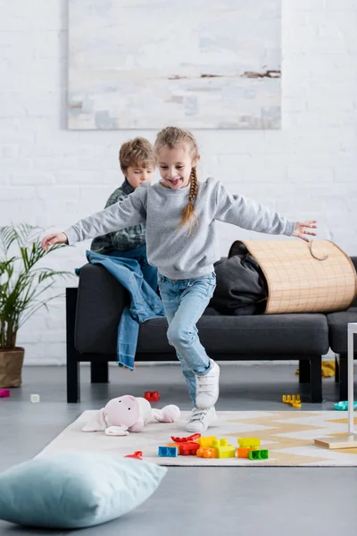 Adorables niños alegres divirtiéndose y jugando en casa - foto de stock