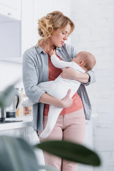 Selektiver Fokus der Mutter, die ihr liebenswertes Kleinkind zu Hause hält — Stockfoto