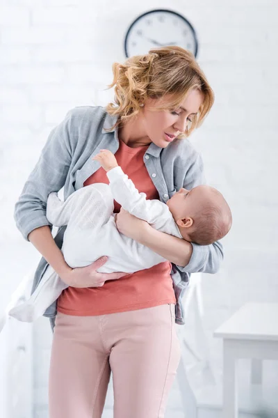 Hermosa madre sosteniendo adorable bebé en casa - foto de stock