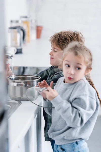 Adorable brother and sister washing pan in kitchen — Stock Photo