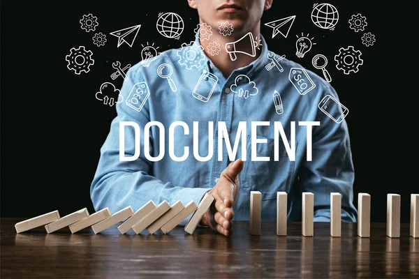 Cropped view of man preventing wooden blocks from falling with word 'documents' and icons on foreground — Stock Photo