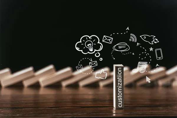 Selective focus of wooden brick with word 'customization' and icons isolated on black — Stock Photo