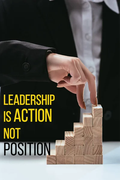 Cropped view of woman climbing with fingers wooden career ladder, 'leadership is action not position' lettering on foreground — Stock Photo
