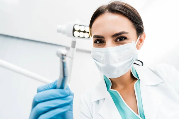 Foco seletivo do dentista feminino com broca na mão — Fotografia de Stock