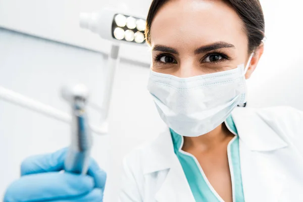 Вибірковий фокус жінки-стоматолога тримає дриль в руці — стокове фото