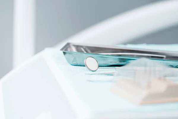 Selective focus of metallic dental mirror near instruments in clinic — Stock Photo