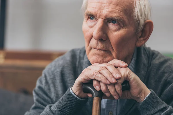 Close up of retired man with grey hair holding walking cane — Stock Photo