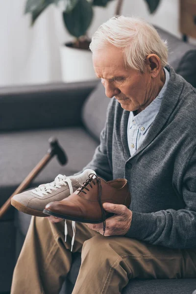 Senior homme choisir entre des chaussures classiques et modernes — Photo de stock