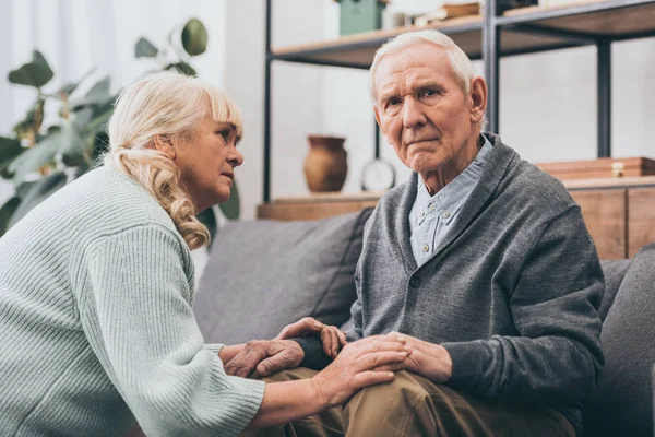 Rentnerin sieht Mann im Wohnzimmer an — Stockfoto