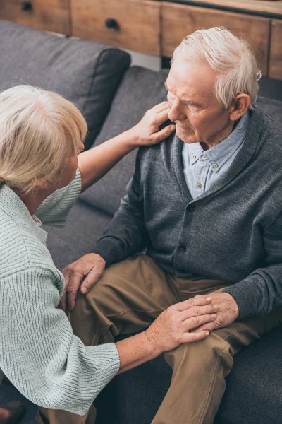 Seniorenpaar hält Händchen und schaut sich zu Hause an — Stockfoto