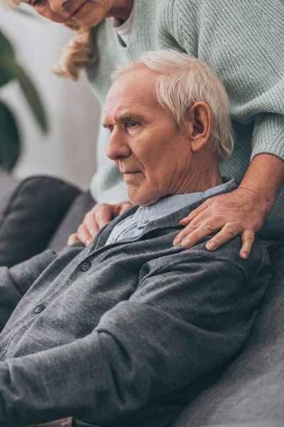 Cropped view of retired wife embrace senior husband shoulders at home — Stock Photo