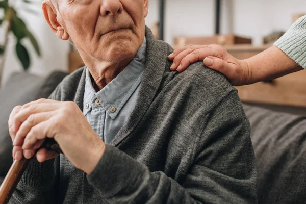 Vue recadrée du pensionné triste avec les mains de la femme sur l'épaule — Photo de stock