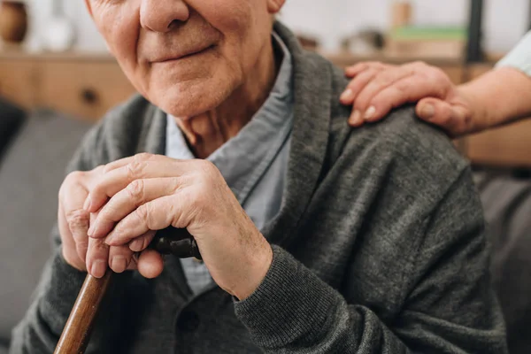 Cropped view of happy pensioner with wife hands on shoulder — Stock Photo