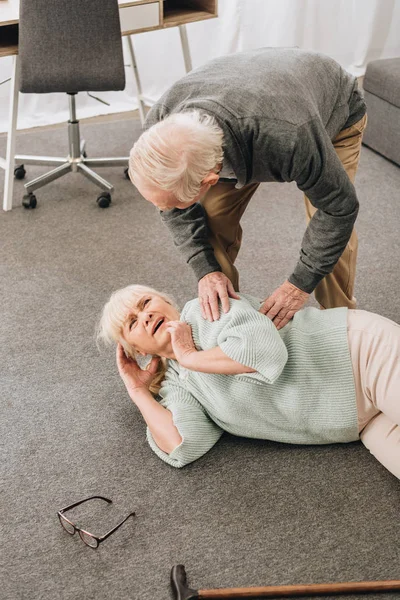 Alte Männer schauen Frau an, die auf den Boden gefallen ist — Stockfoto